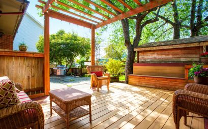 backyard deck with wicker furniture and pergola.